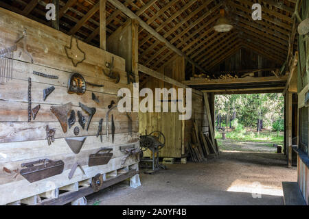 Farm tools hanging on the wall of an old Blacksmith shop preserved at Kleb Woods Nature Park. Houston, Texas, USA. Stock Photo