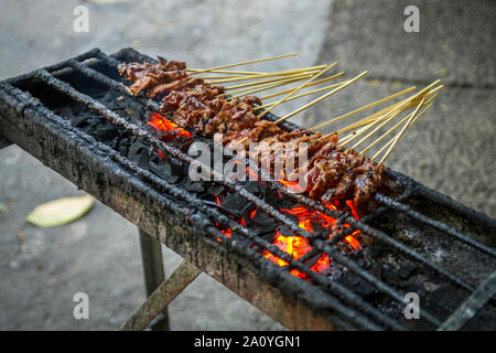 Chicken satay grill at a busy street food market Stock Photo