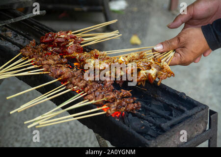 Chicken satay grill at a busy street food market Stock Photo