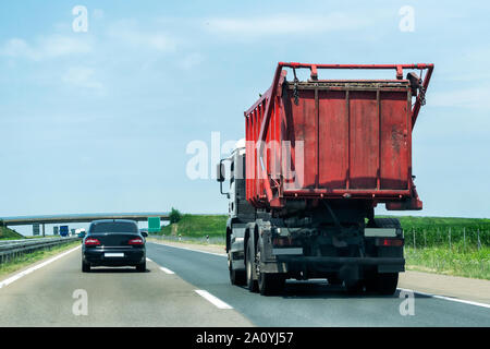 Garbage truck on a rural country highway or motorway with light traffic Stock Photo