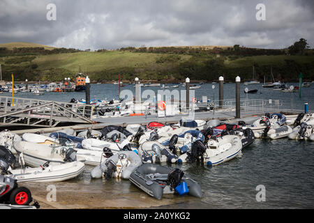 Whitestrand Pontoon in Salcombe Devon, covered with small rubber boats moored up whilst people visit the town. Salcombe, Devon Stock Photo