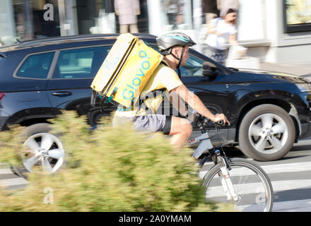 Belgrade, Serbia - September 17, 2019 : One young man working for Glovo delivery service, riding a bike in the city street traffic Stock Photo