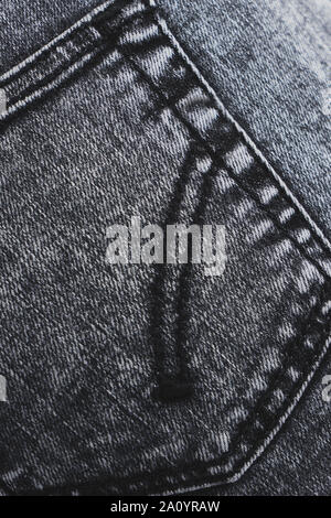 Grey jeans back pocket closeup texture. Stitched stonewash denim. Vertical photo. Stock Photo
