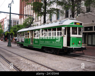 MEMPHIS, TENNESSEE - JULY 22, 2019: A vibrant green electric trolley car cruises along on the Main Street track on a cloudy day summer day in Memphis, Stock Photo