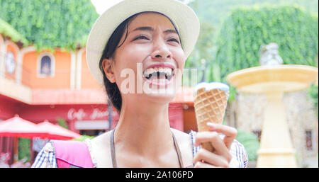Beautiful female holding and eating ice cream on summer holidays Stock Photo
