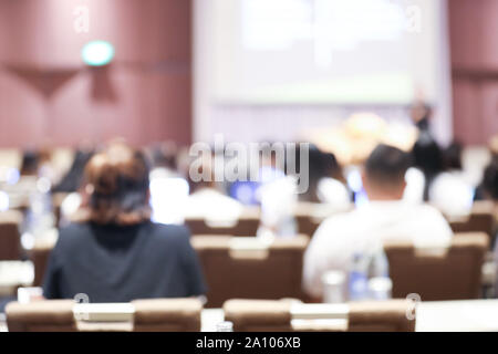 Abstract blurry background of employees seminar and De-focus teamwork staffs working meeting in conference room with projector screen. Stock Photo