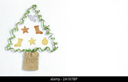 Handmade Christmas tree made from recycled gift twine and hemp gift bag with textile decorations made from recycled material on white background with Stock Photo