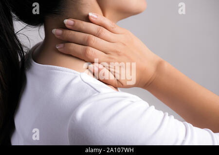 Closeup woman neck and shoulder pain and injury. Health care and medical concept. Stock Photo