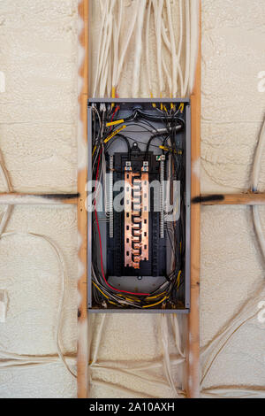 Electrical Circuit Breaker panel in new home construction, with spray foam insulation and negative space Stock Photo