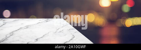 marble table top product display background with blur night cityscape.left perspective stone patio counter with street bokeh lights.Banner mockup pres Stock Photo