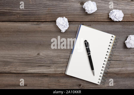 Notepad and pen with crumpled paper on wooden background. No ideas concept Stock Photo
