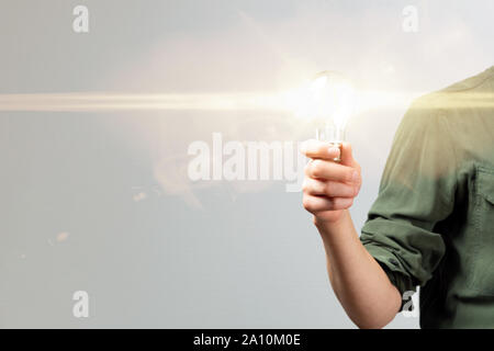 Business woman hand holding lightbulb in office. Concept saving energy, idean and creativity Stock Photo
