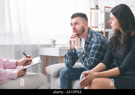 Young grumpy couple at marital counseling therapy Stock Photo