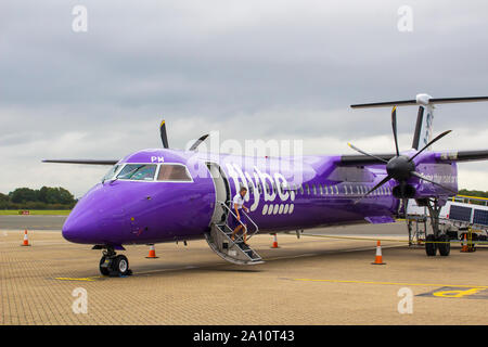 16 September 2019 A FlyBe Dash 8 Commercial Airliner with luggage and passenger handlers on the apron at Southampton City Airport in Hampshire England Stock Photo