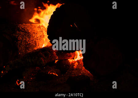 Close up of bonfire with sparks at night. Heat from burning logs and coals in the dark Stock Photo
