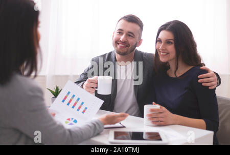 Young millennial couple enjoying coffee, listening to financial advisor Stock Photo