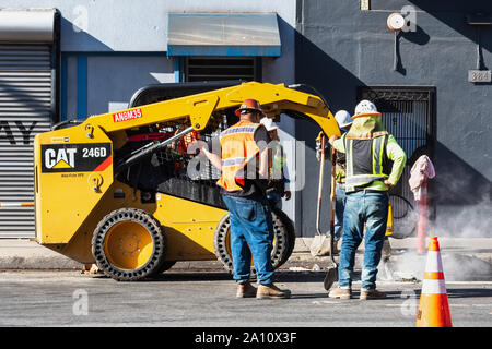 Sep 20, 2019 San Francisco / CA / USA - CAT skid steer with Jackhammer attachment, breaking the concrete on a street in SOMA District Stock Photo
