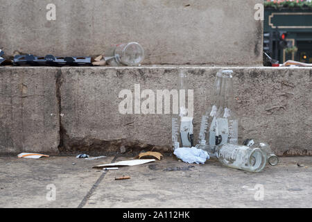 Empty bottles of beer and liquor left abandoned  at foot of nameless monument in London Stock Photo