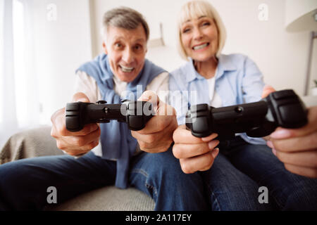 Modern grandparents. Senior couple playing video games Stock Photo