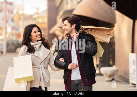 Happy shopaholics walking with shopping bags after making purchases Stock Photo