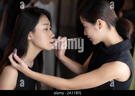Makeup artist applying makeup on model Stock Photo