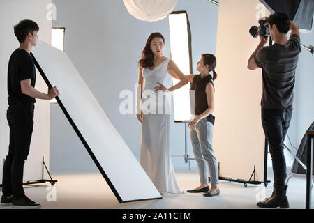 Photographer taking picture of model in studio Stock Photo