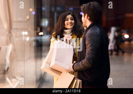 Young couple shopping together. Girl asking boyfriend to buy shirt Stock Photo