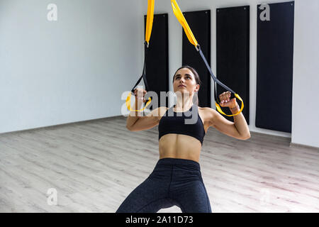 Athletic female performing upper-body exercise on fitness equipment Stock  Photo - Alamy