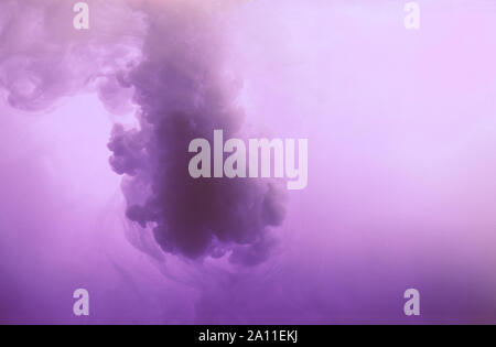 Color drop in water, photographed in motion. Ink swirling. Cloud of silky ink under water on blue background. Colorful ink in water, ink drop Stock Photo