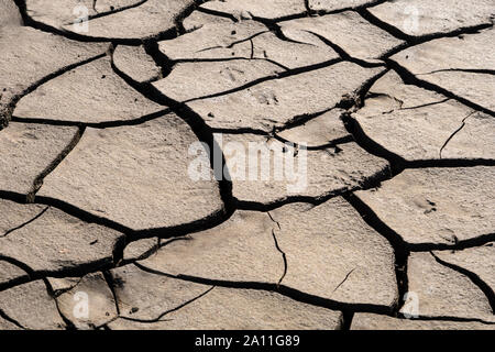 Dried and cracked mud on a dry reservoir floor Stock Photo