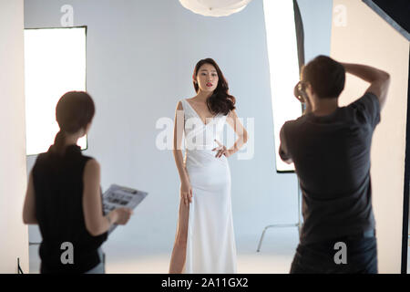 Photographer taking picture of model in studio Stock Photo