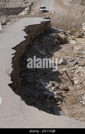 Side of broken asphalt road collapsed and fallen caused by sinkholes near the Dead Sea, Israel. Israel sits on an active geologic fault line ('Syrian-African'), with predictions of a serious earthquake and aftermath tremors that could ravage the country at any moment, Stock Photo