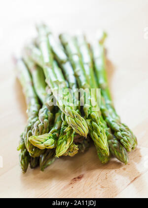 Bunch of Asparagus tips on a wooden surface Stock Photo