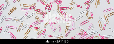 Pattern of multicolored paper clips on grey background. Back to school. Office, business, paperwork, education concept. Banner. Stock Photo