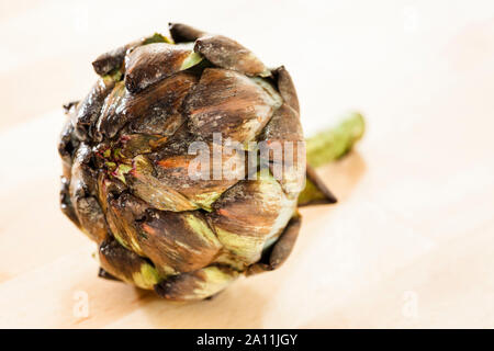 Globe Artichoke on a wooden surface Stock Photo