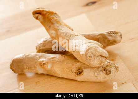 Root ginger on a wooden surface Stock Photo