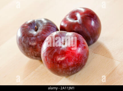 Plums on a wooden surface Stock Photo