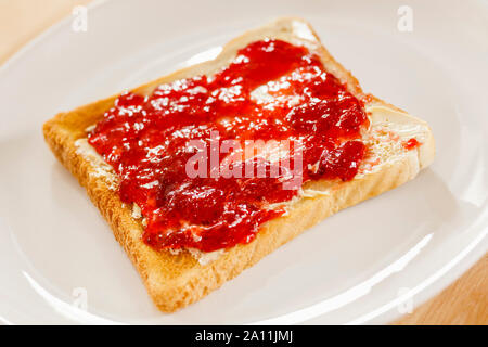 Toast and strawberry jam on a white plate Stock Photo
