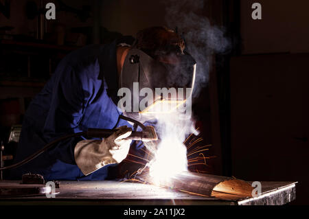 Worker welding in workshop. Stock Photo