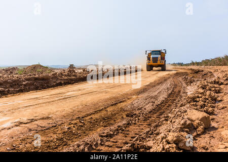 Industrial dump truck tipper bin moves earth soil on new industrial property earthworks development plateau in countrysidse Stock Photo