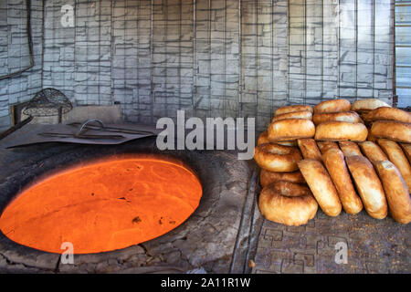 Hot Tandoor for baking and ready-made oriental flatbreads close up on the market Stock Photo