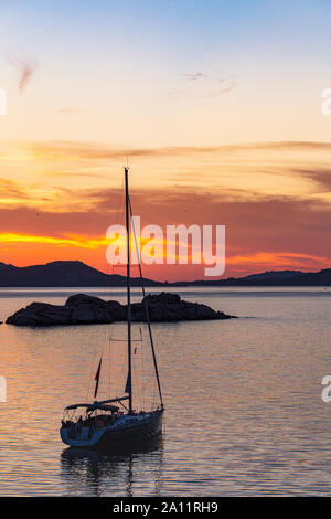 Sardinia: Coastal, Colourful, Sunset View Looking Across a Golden, Tranquil Mediterranean to the Islands of La Madallena and Caprera With Moored Yacht. Stock Photo