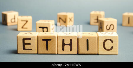 Wooden blocks with the word Ethic. Defending, systematizing and recommending concepts of right and wrong conduct. Moral philosophy Stock Photo