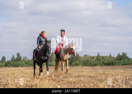 Slavuta, Ukraine - september 22, 2019 : Ukrainian guy and girl on horseback participate in the Ethno-eco festival Kolodar in city Slavuta, Ukraine Stock Photo
