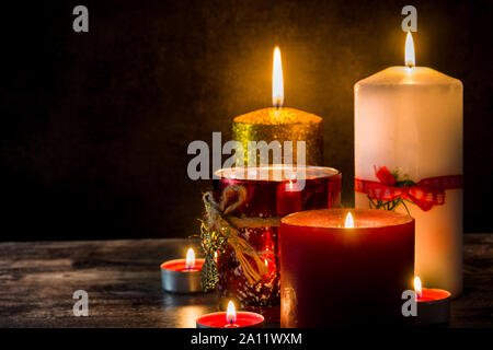 Christmas candles on wooden table and black background. Copy space Stock Photo