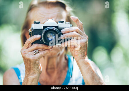 Elderly woman with a vintage film photo camera Stock Photo