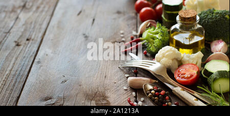 Fresh vegetables, olive oil and spices on wooden table Stock Photo