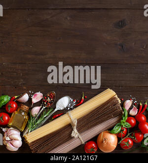 Three types of spaghetti, vegetables and herbs  on a wooden table Stock Photo
