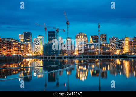 Oslo, Norway. Night View Embankment And Residential Multi-storey House In Gamle Oslo District. Summer Evening. Residential Area Reflected In Sea Water Stock Photo