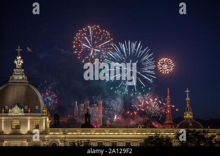 LYON, FRANCE - JULY 14, 2019: Fireworks bursting over Hotel Dieu in Lyon for French National Holiday, Bastille day, while Basilique de Fourviere Basil Stock Photo